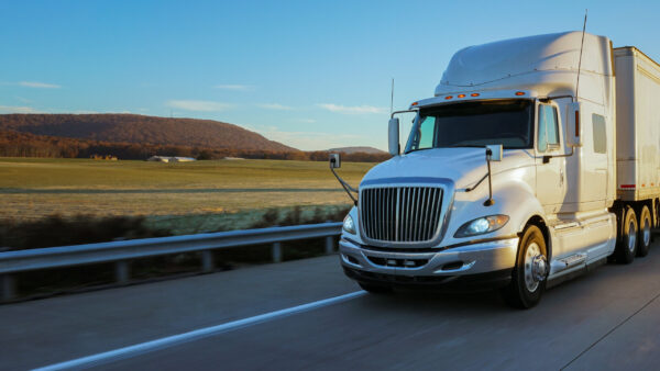 Tractor trailer truck driving down a highway